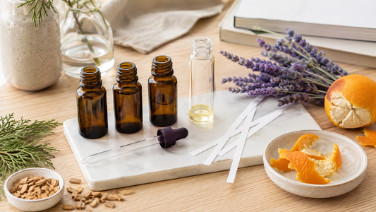Essential oil blending setup with amber bottles, scent strips, citrus, lavender, and wood